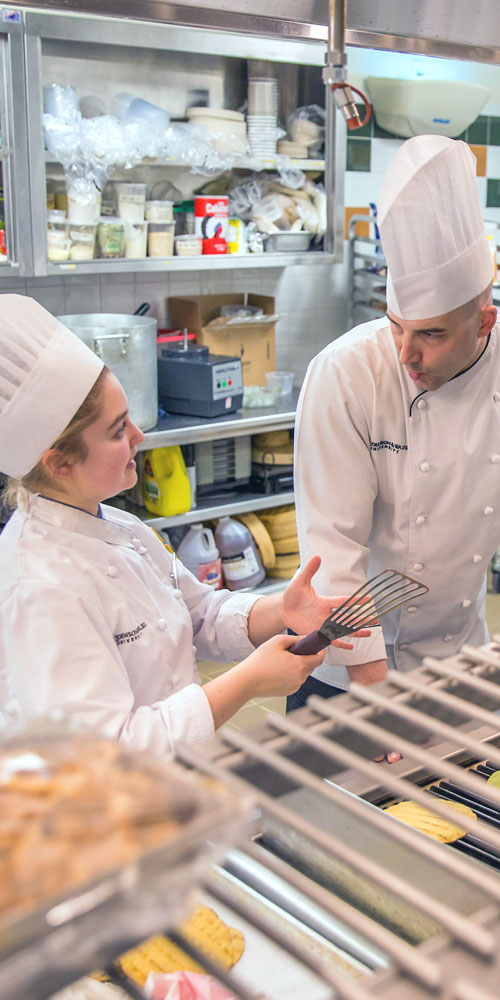 Culinary Arts student in the kitchen with Chef Jon Poyourow.