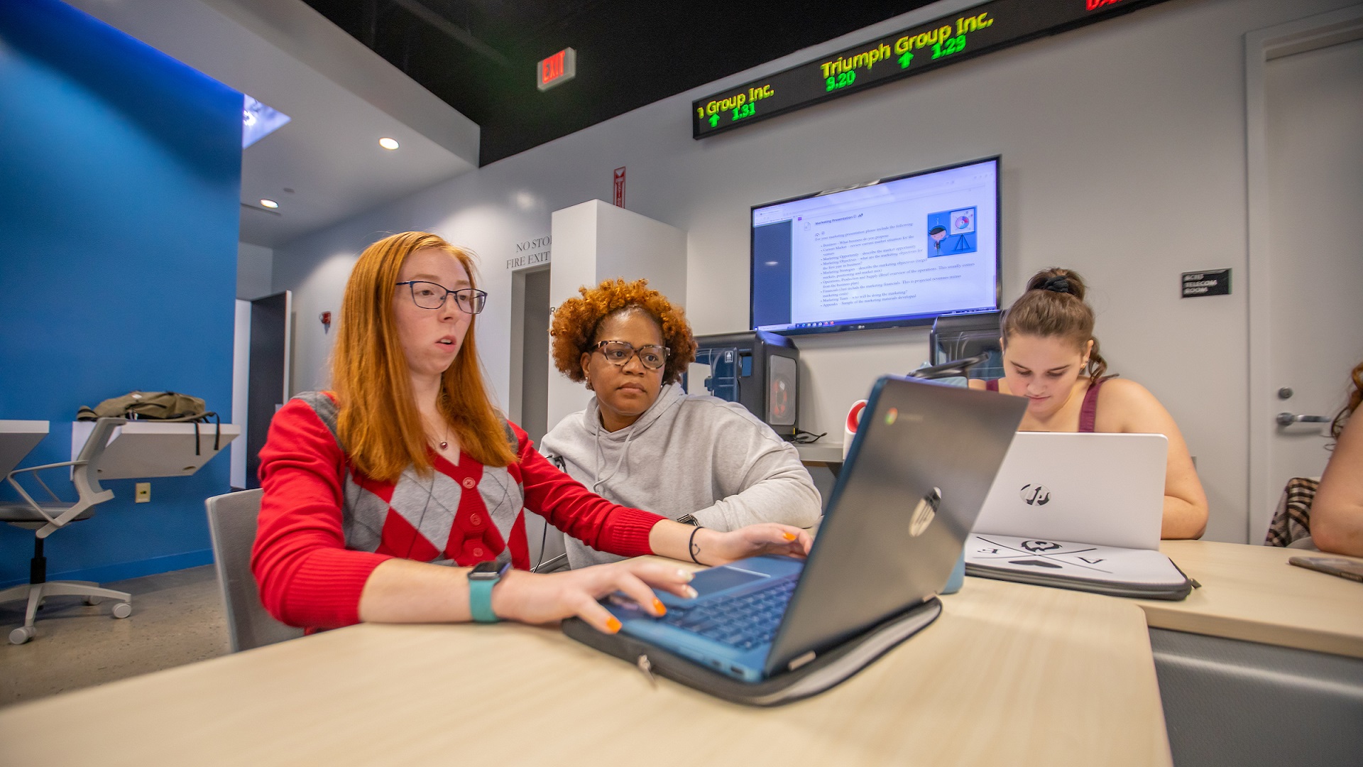 college students working on laptop together