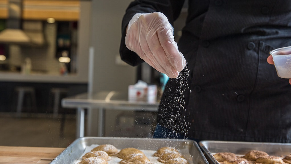 food science student sprinkling salt on food