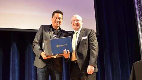 Bruce Poon Tip receiving honorary certificate from Dean Paul McVety