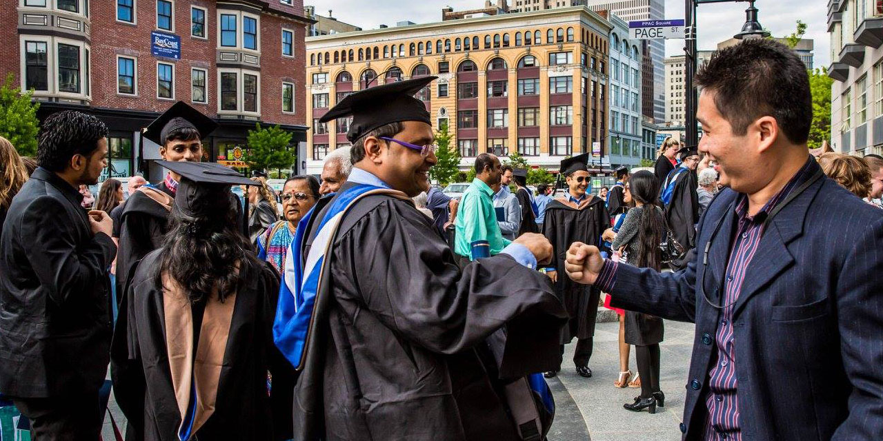 Grads share a fist bump.