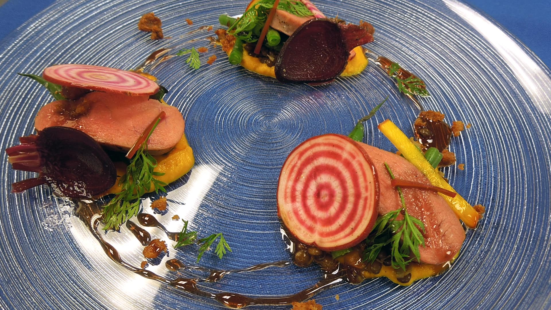 Demo plate of pickled and sliced beets with herbs and a vinaigrette.