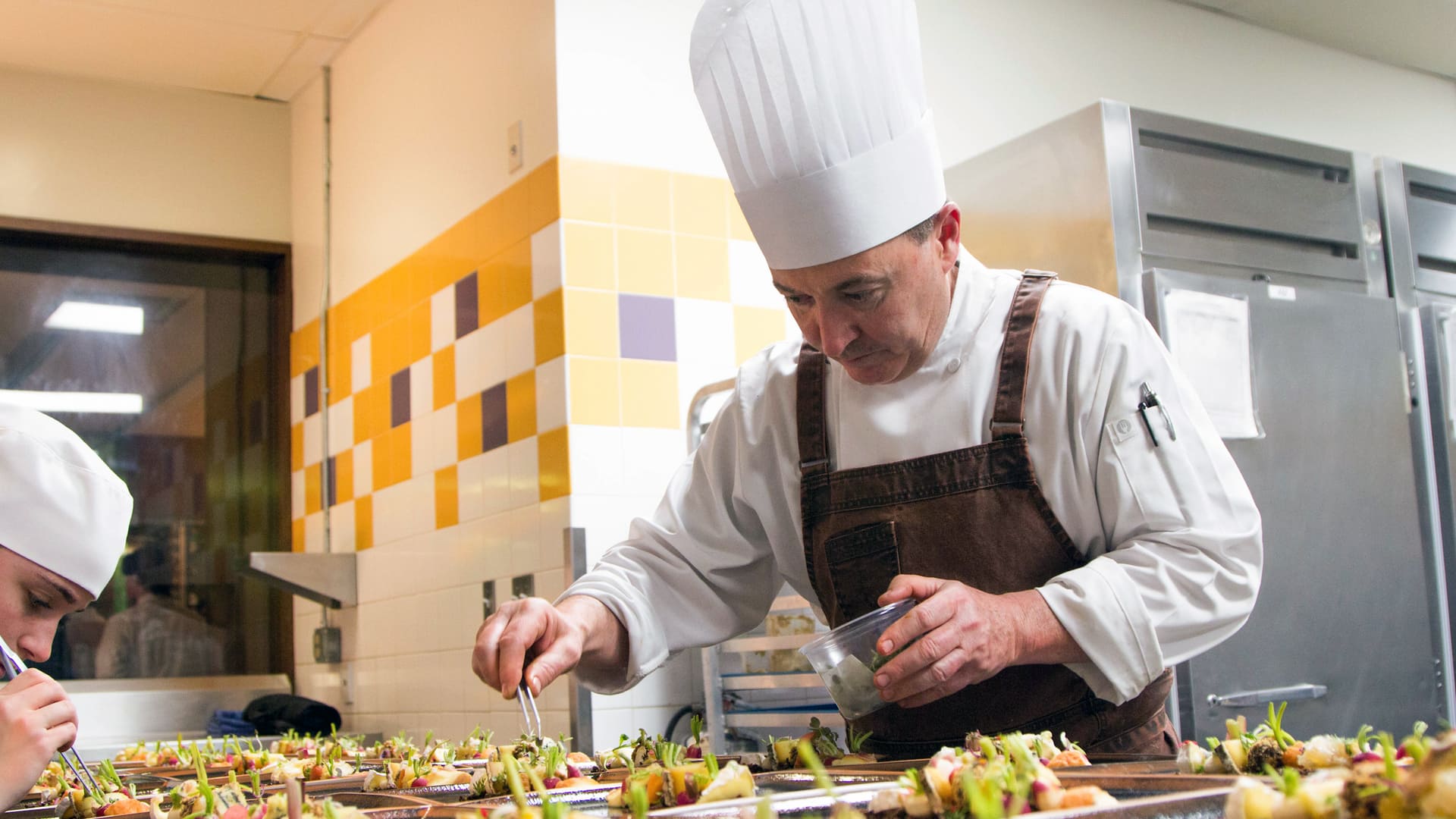 Chef Tom Condron '88 working on plated dish.