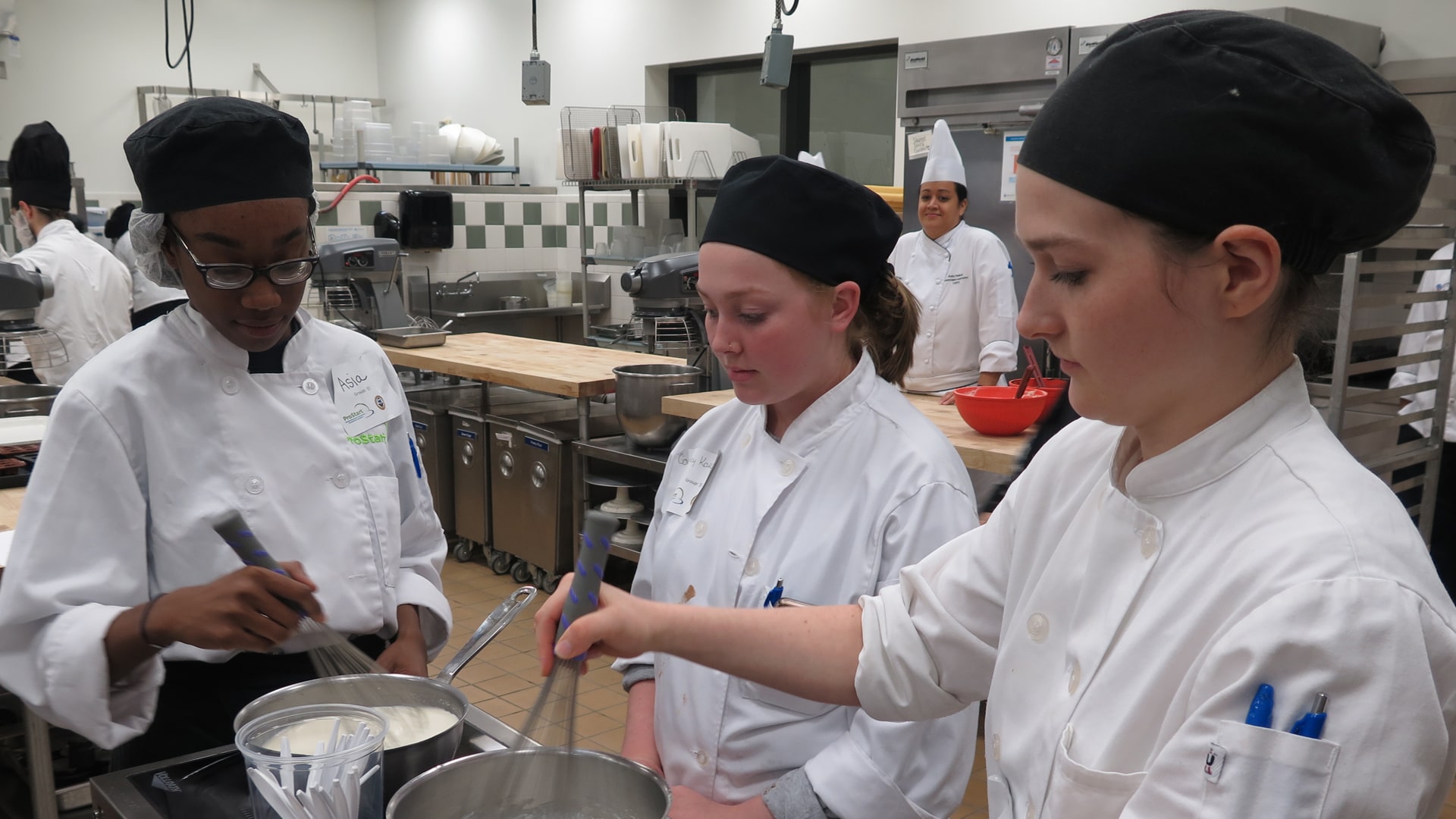 High School students learning culinary skills in JWU culinary lab.