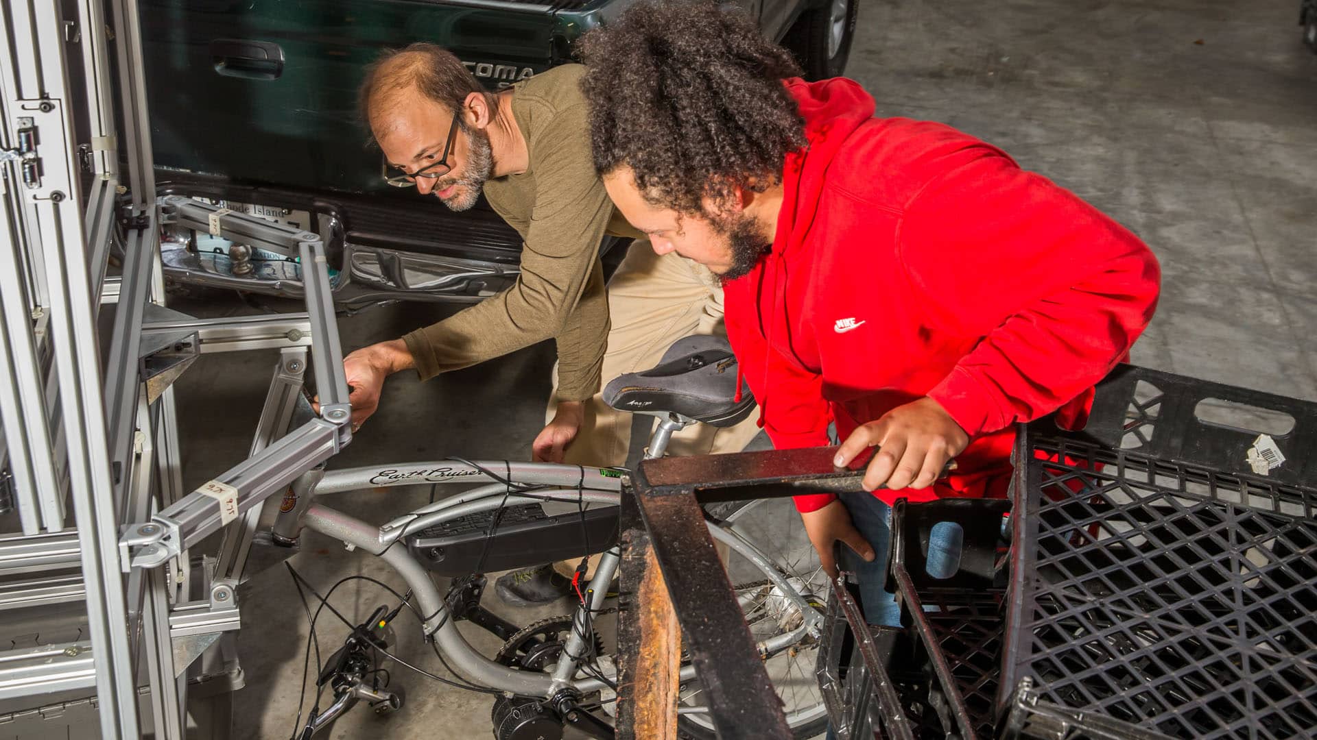 ASSOCIATE PROFESSOR JONATHAN HARRIS WORKS WITH A STUDENT ON DESIGNING A CUSTOM-BUILT FOOD CART.