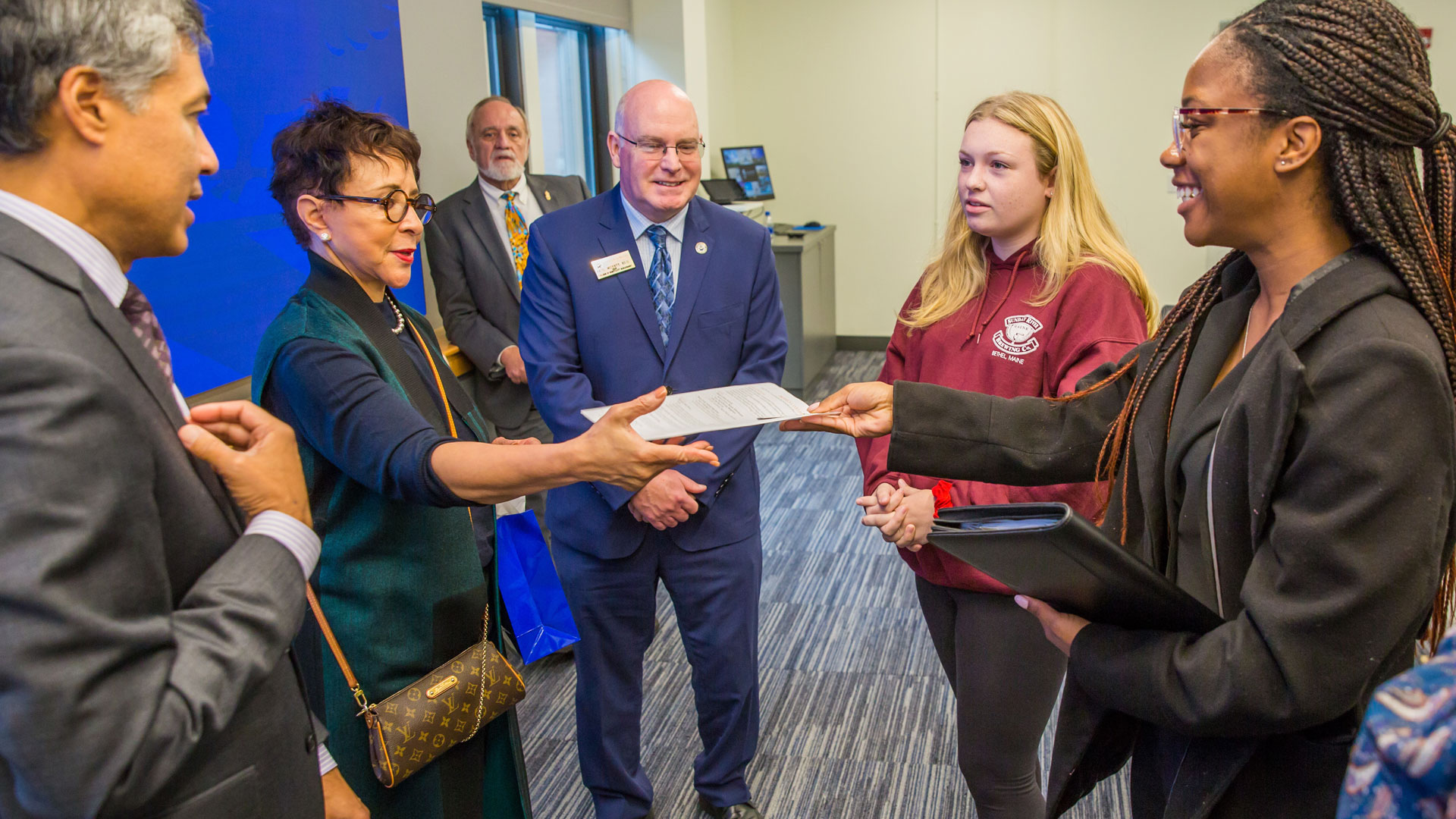 Prophecy Collier (far right) meets Sheila Johnson and passes her a copy of her resume