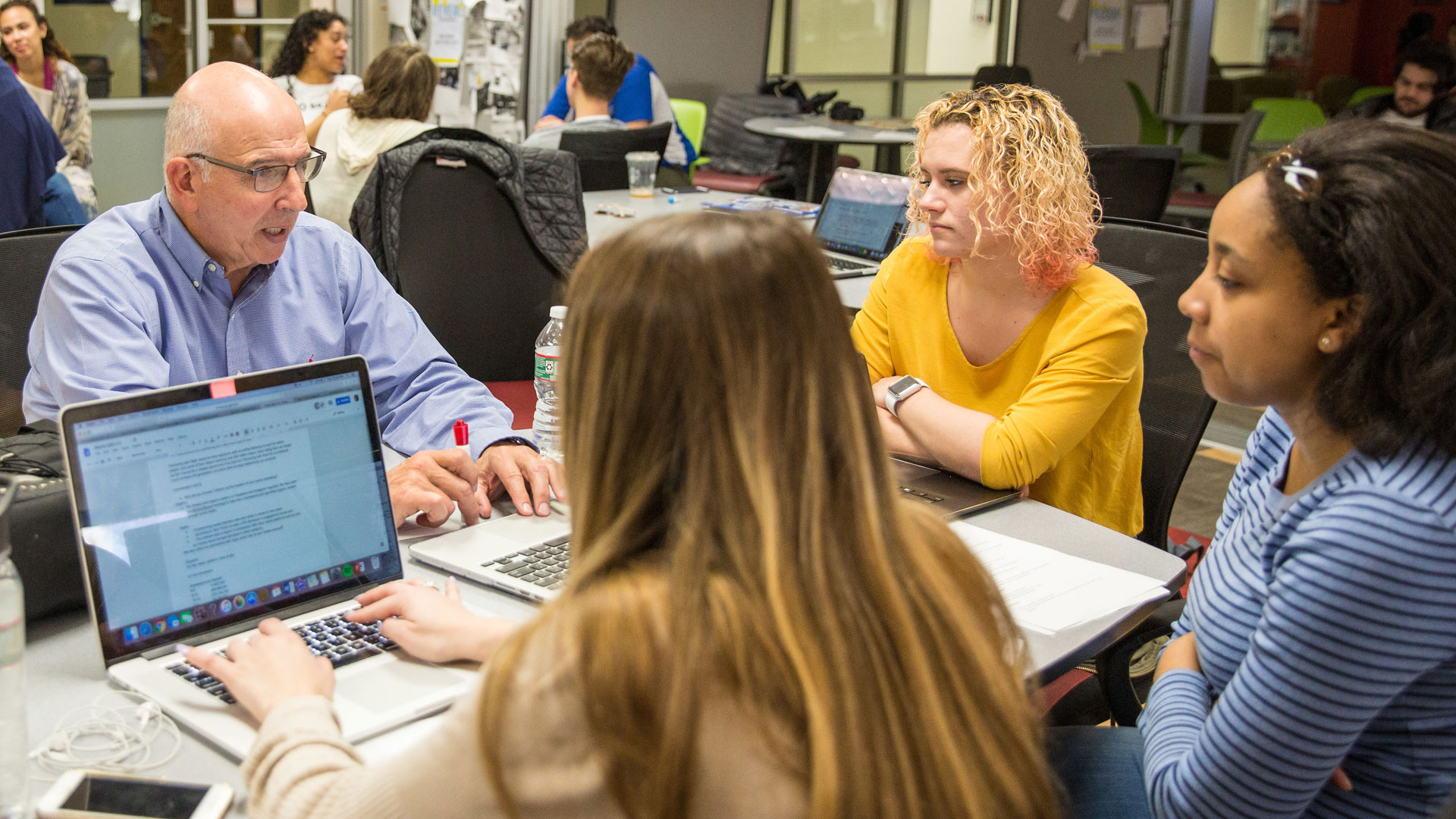 Associate Professor Oscar Chilabato goes over ad concepts with Providence Campus students.