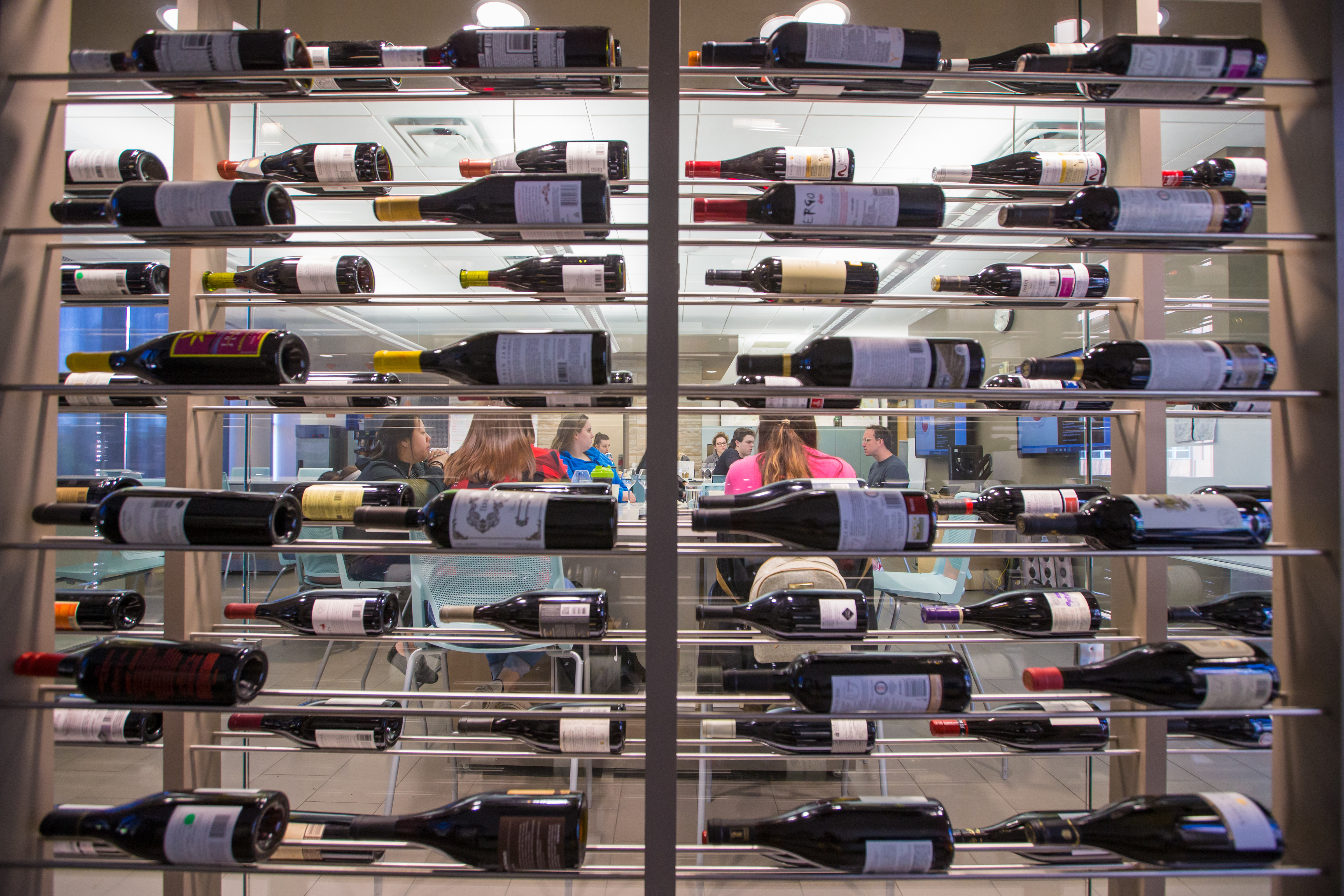 Hospitality classroom viewed through rows of wine racks