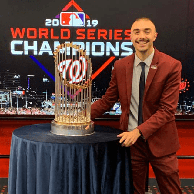 JWU alumni John Michos '18 posing with World Series Trophy