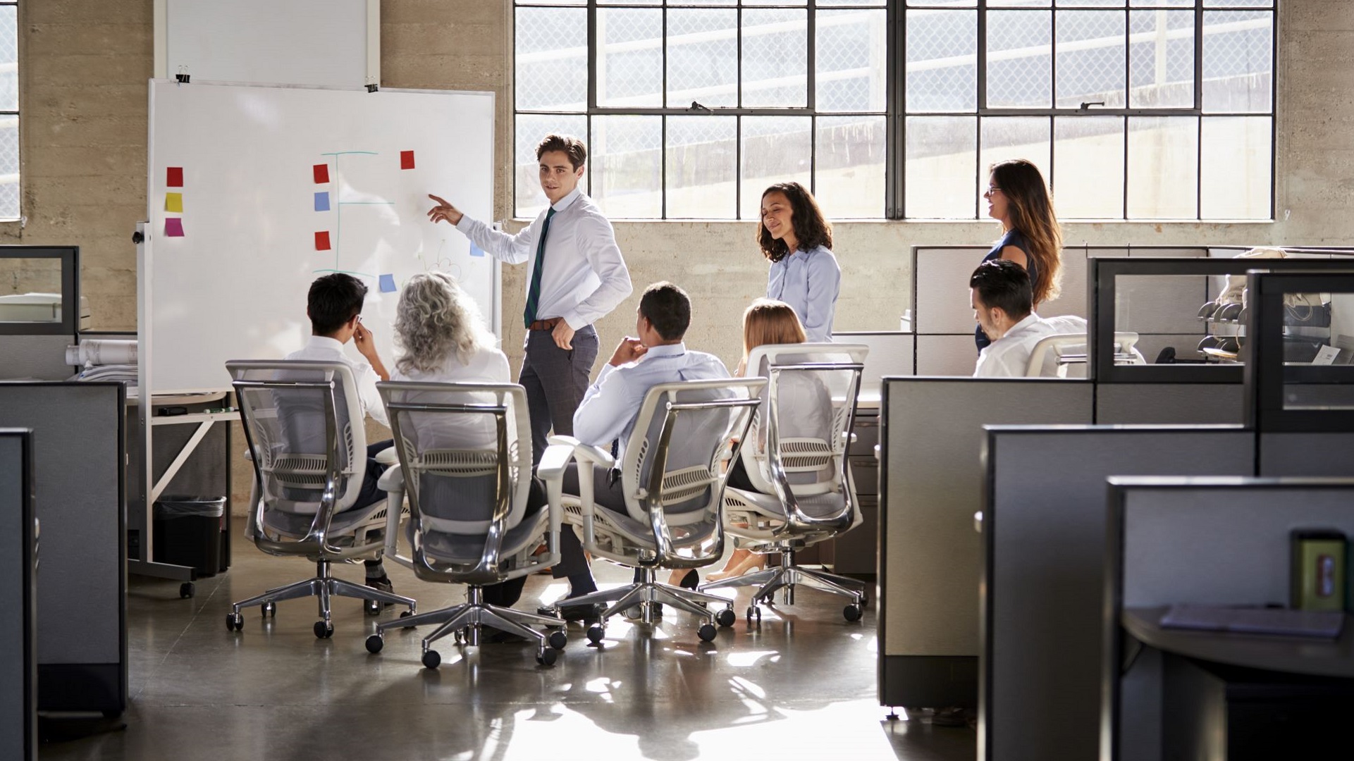 Young man presenting in an office to his peers.