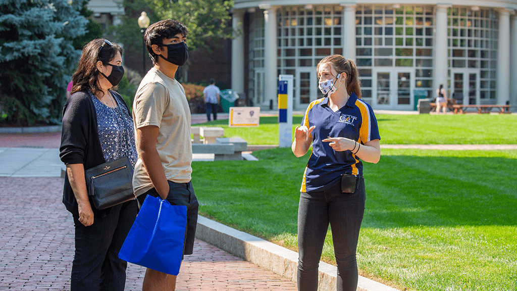 Student giving a tour of campus to prospective student and family member