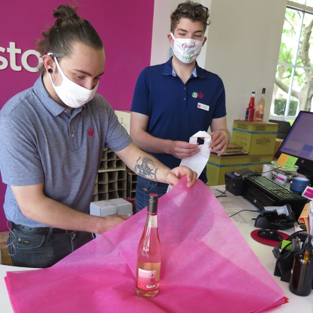 JWU alums Matt Rehm and Kolton Davis wrapping a wine order.