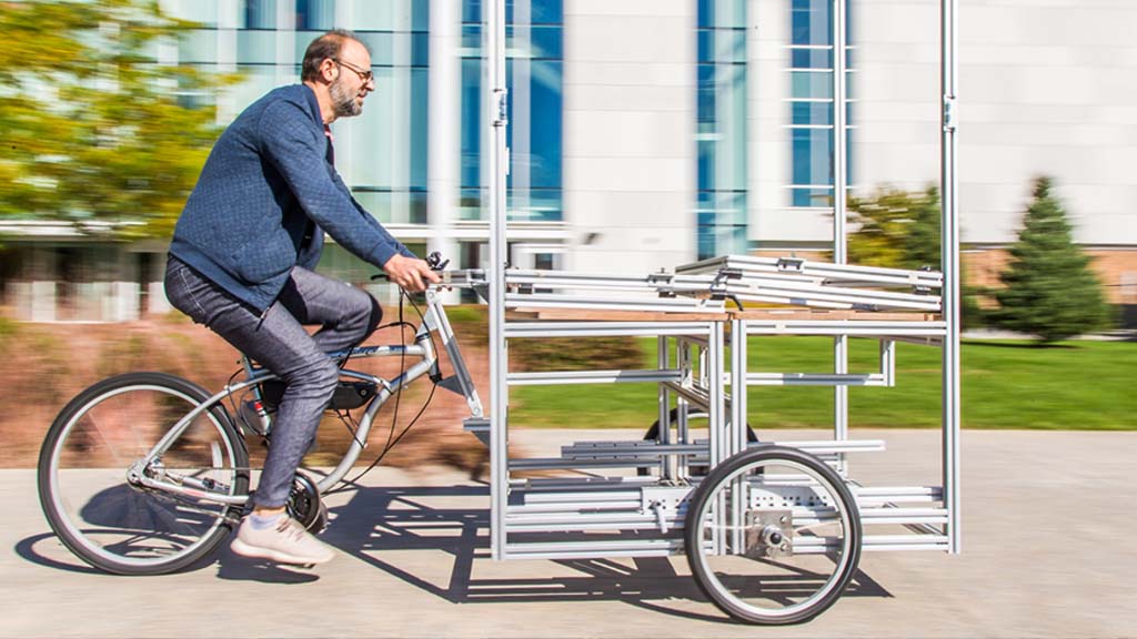 Harris testing the bike cart prototype he built with one of his students.