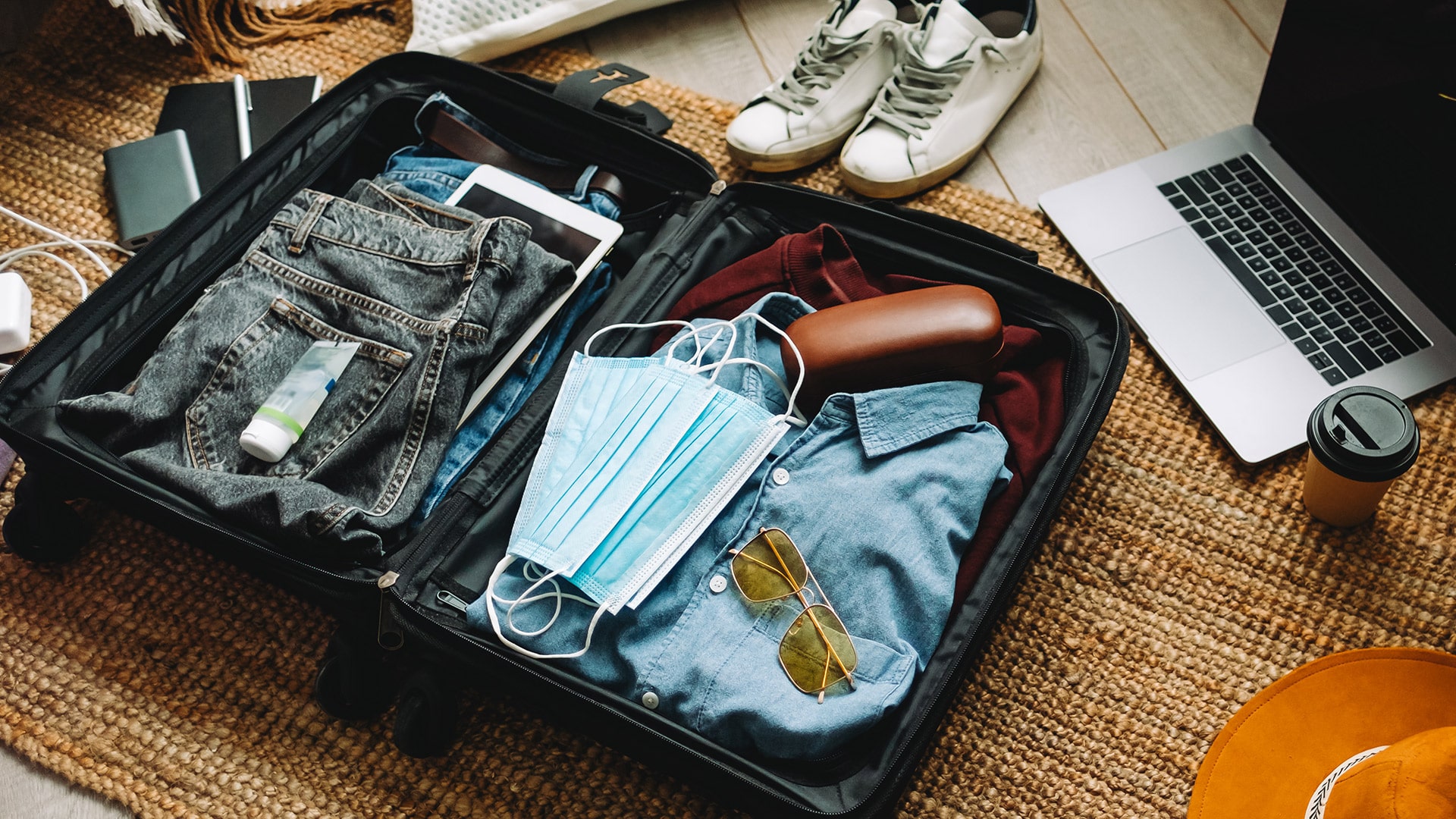 image showing a suitcase full of folded clothes and other contents