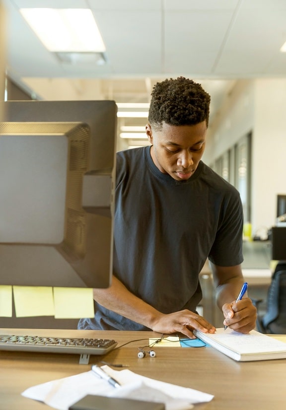 Male student works on computer in public space