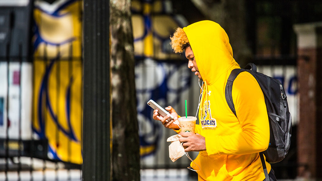 Student on their phone walking on campus