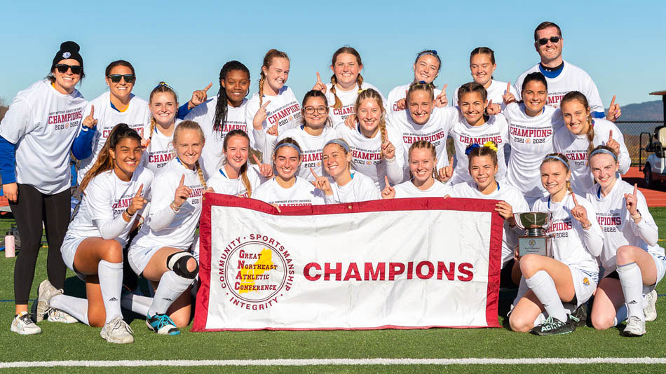 The JWU Women's Field Hockey team proudly holds up its GNAC 2021 Championship banner