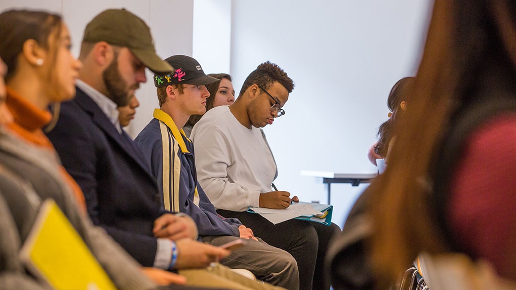 Photo of tudent taking notes during a lecture