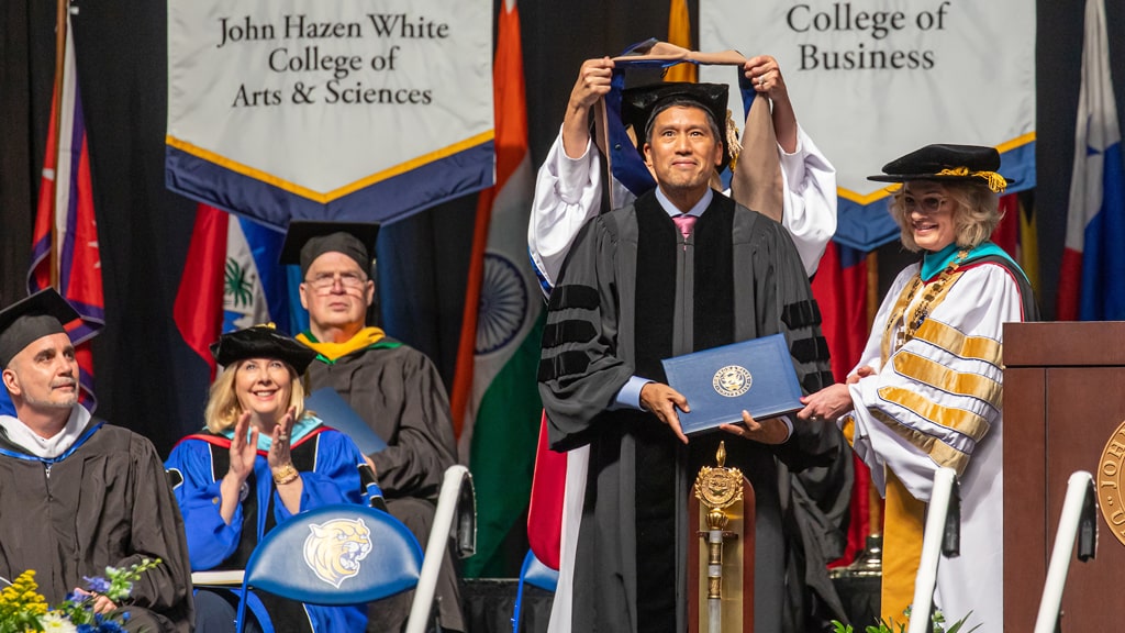 Bruce Poon Tip '22 Hon. receives his academic regalia.