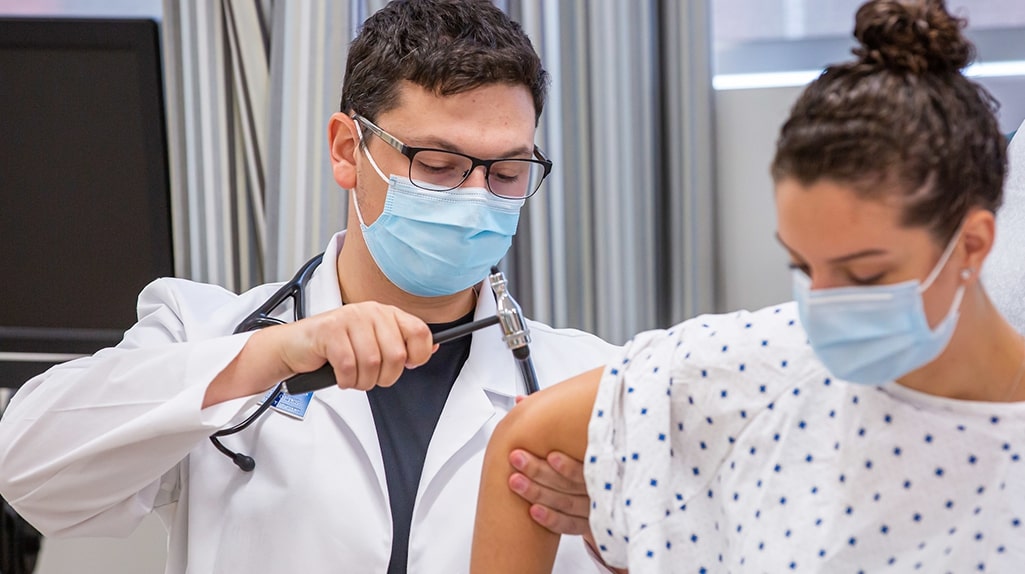 Male nursing student in a lab examines a patient