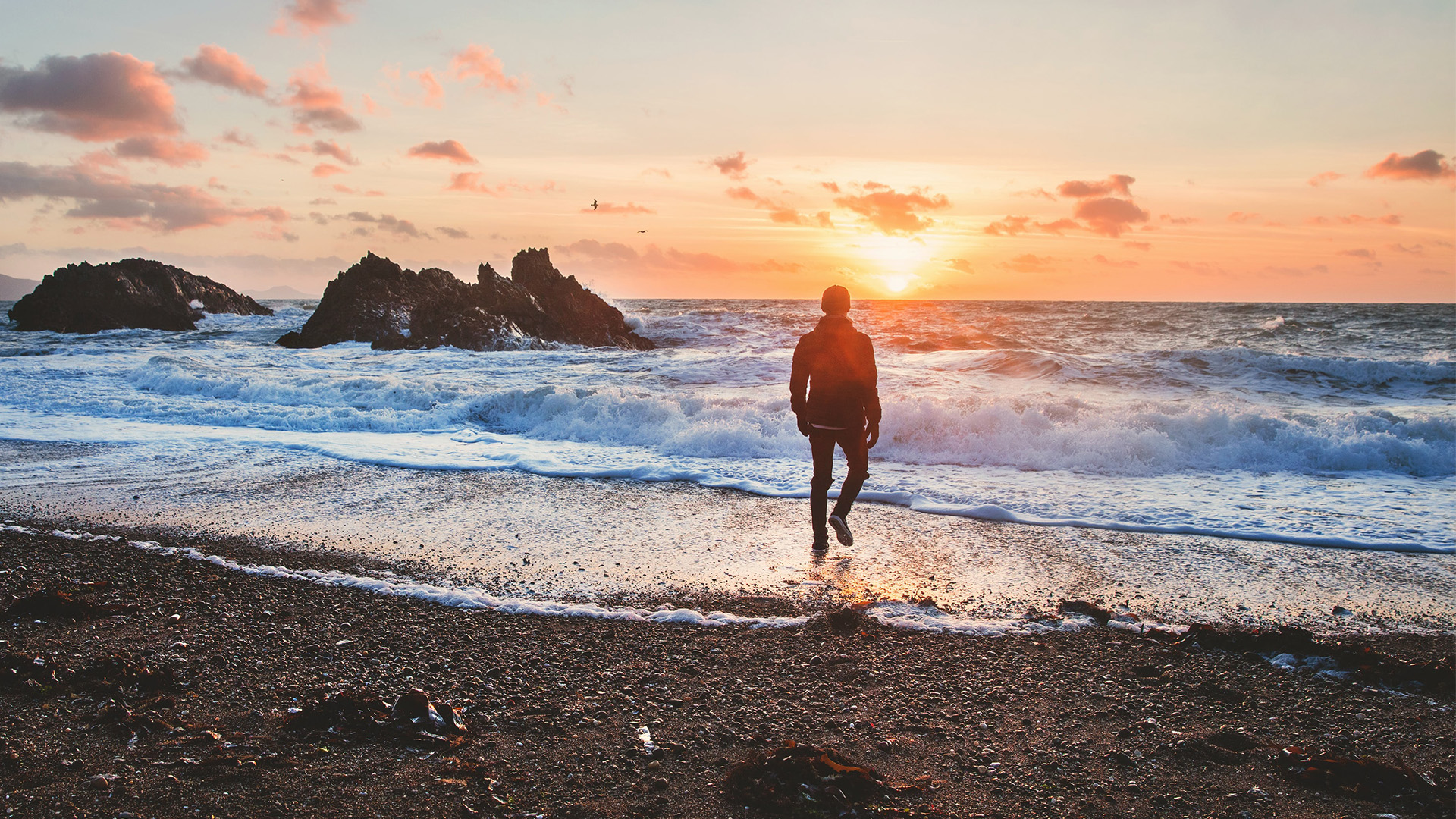 Sunrise at beach with man at the shore