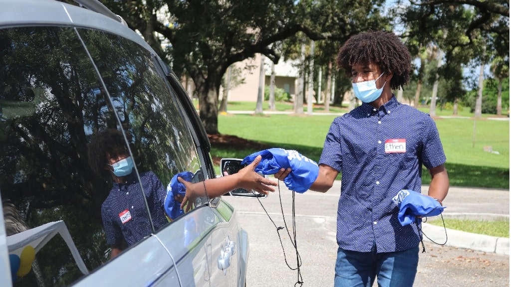 a boy giving out hello hygienics bags