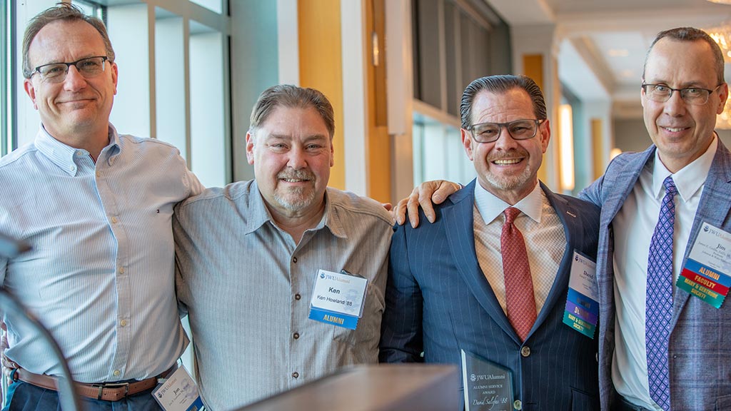 PHOTO OF JWU ALUMS JON LEDVERSIS ’88, KEN HOWLAND ’88, DAVID SALCFAS ’88 AND JIM GRIFFIN, ED.D. ’88, ’92 M.S.