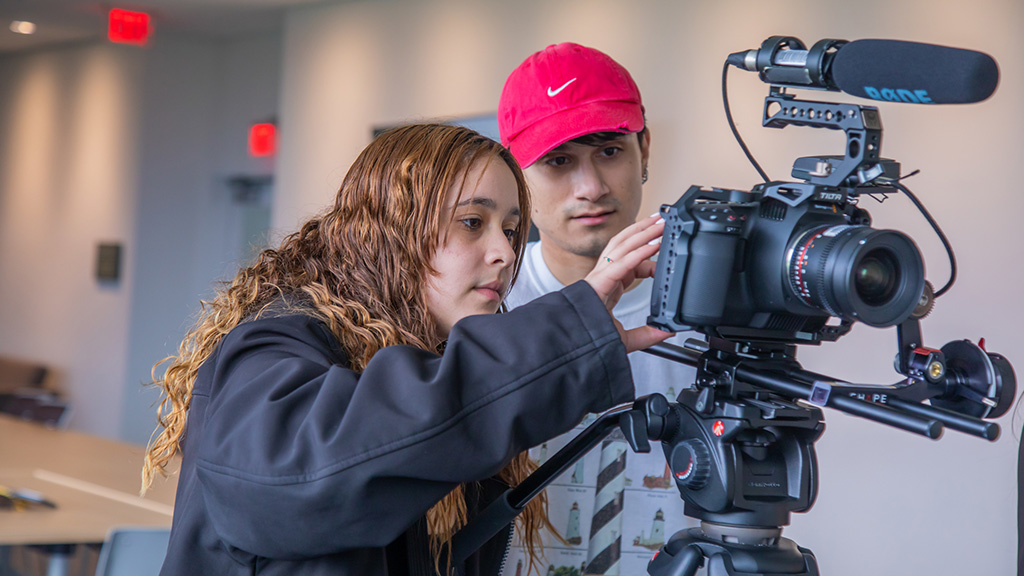 Two students looking at a camera