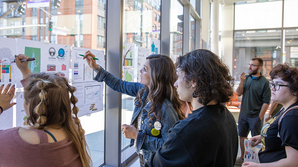 Professor Jimenenz-Elliot working with students on their designs.