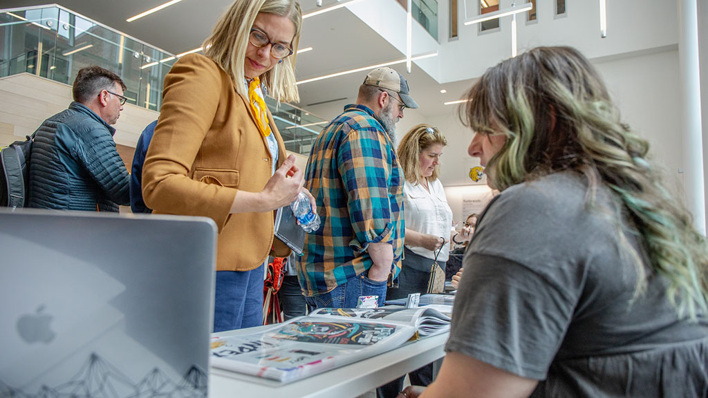 A staff member looking at a students portfolio