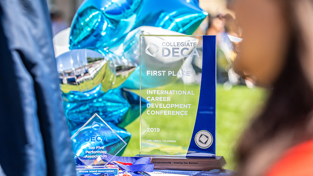 A closeup of JWU's DECA trophy on a table