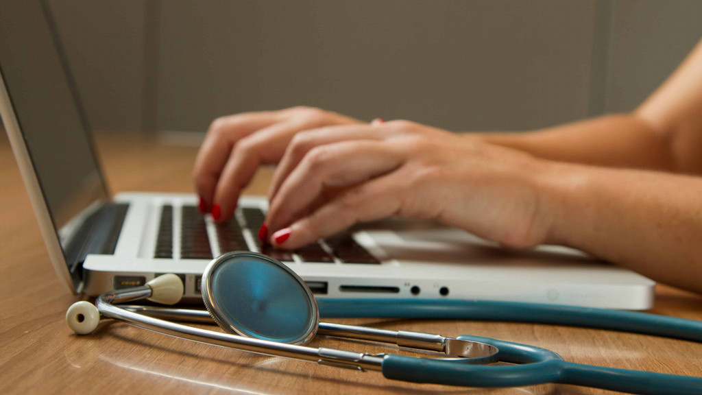 Nurse typing at a keyboard.