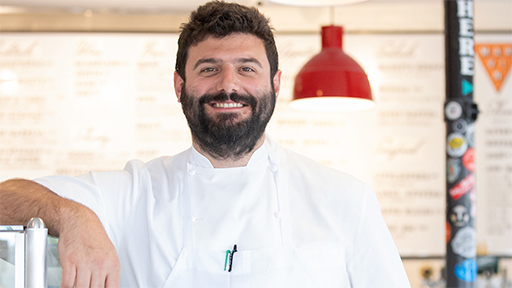 photo of Robert Andreozzi '12 smiling at the business he owns, Pizza Marvin