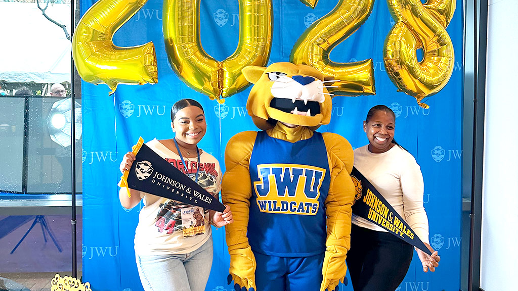 Wildcat Willie posing with a mother and daughter at ASD