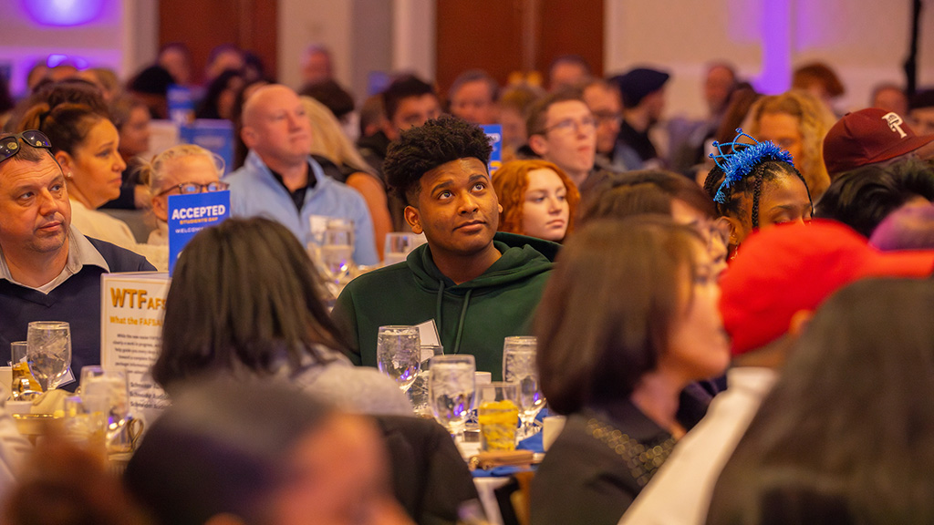 A student sitting in a crowd