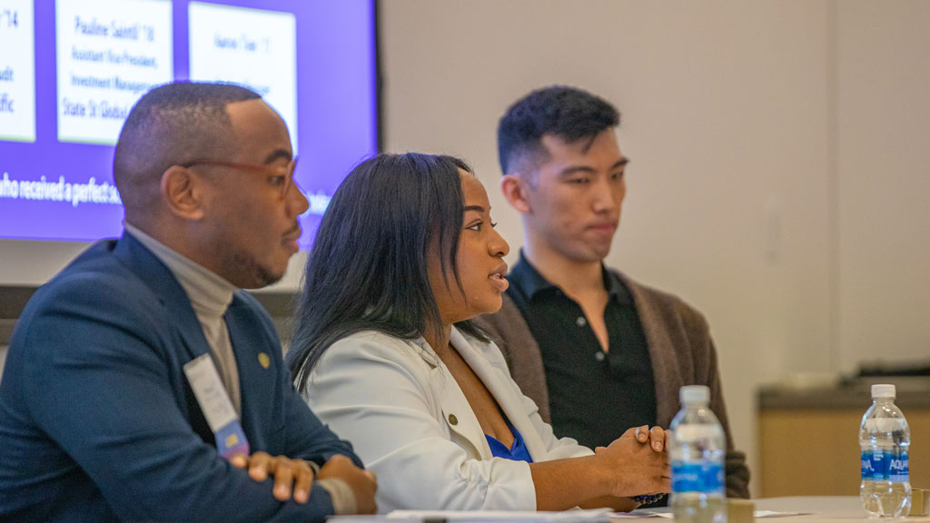 Pauline Saintil '18 speaks at a panel while surrounded by two other alumni