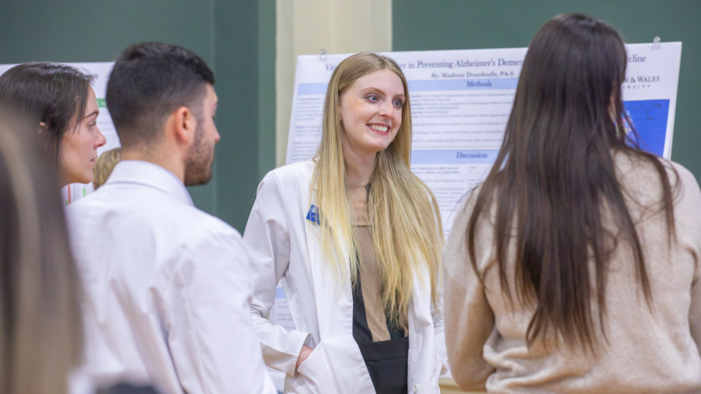 Aurora DiMarco, center, is captured smiling while speaking with fellow PA students