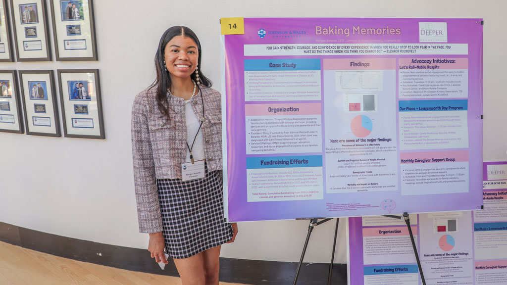 photo of Morgan Belardo ’24 posing with her 2024 symposium project poster