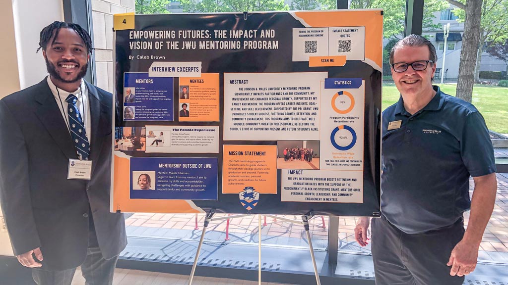 photo of Caleb Brown '25 and Tim Stiles posing with Caleb's symposium project poster