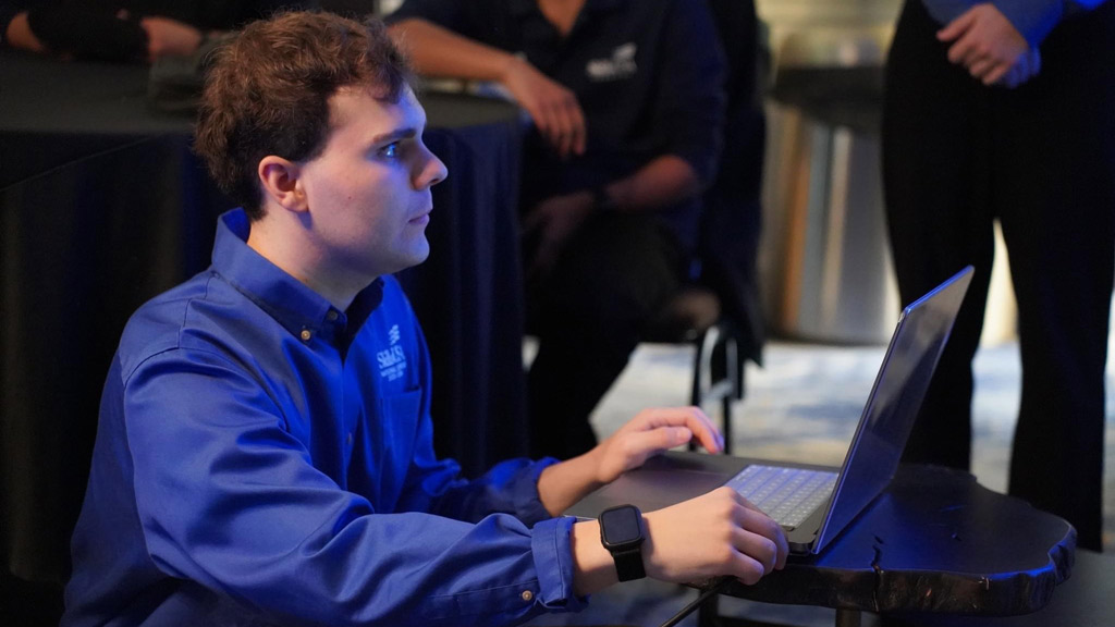 photo of a young man concentrating while looking at a laptop