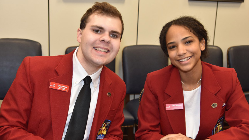 photo of Tyler Miles '28 posing smiling next to a young woman