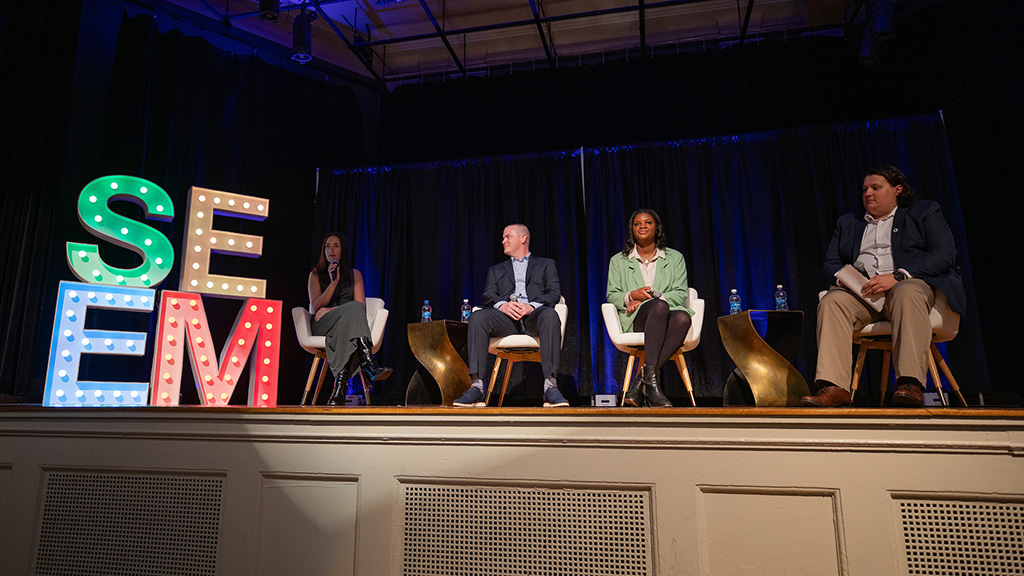 The panel of SEEM alumni sitting on stage at the conference.