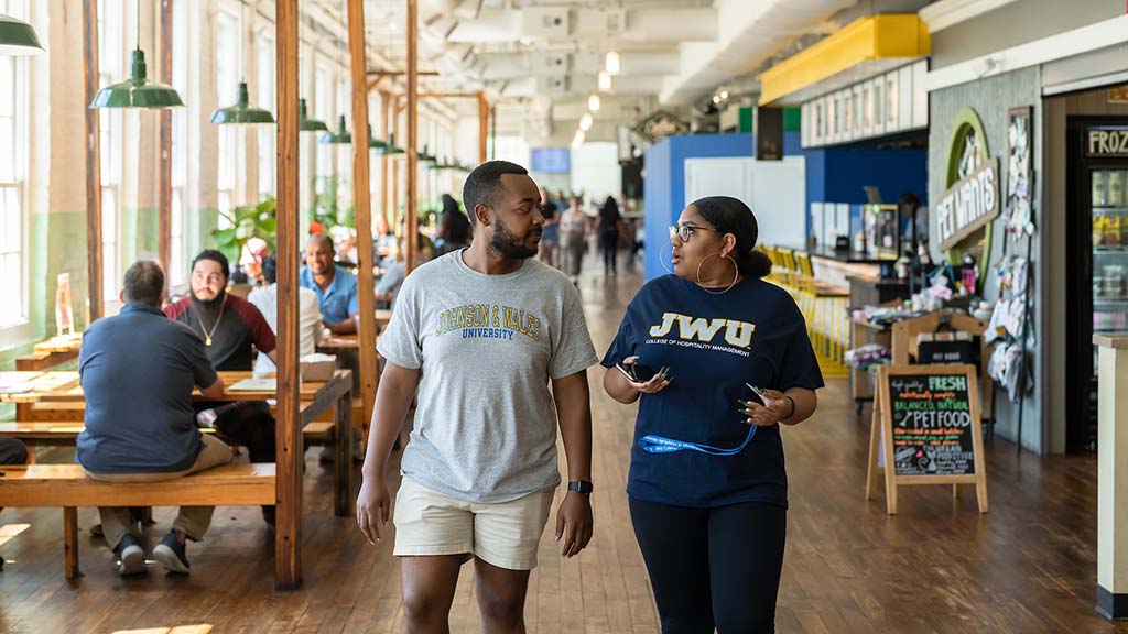 JWU students stroll inside Optimist Hall, which dining areas and vendors on display.