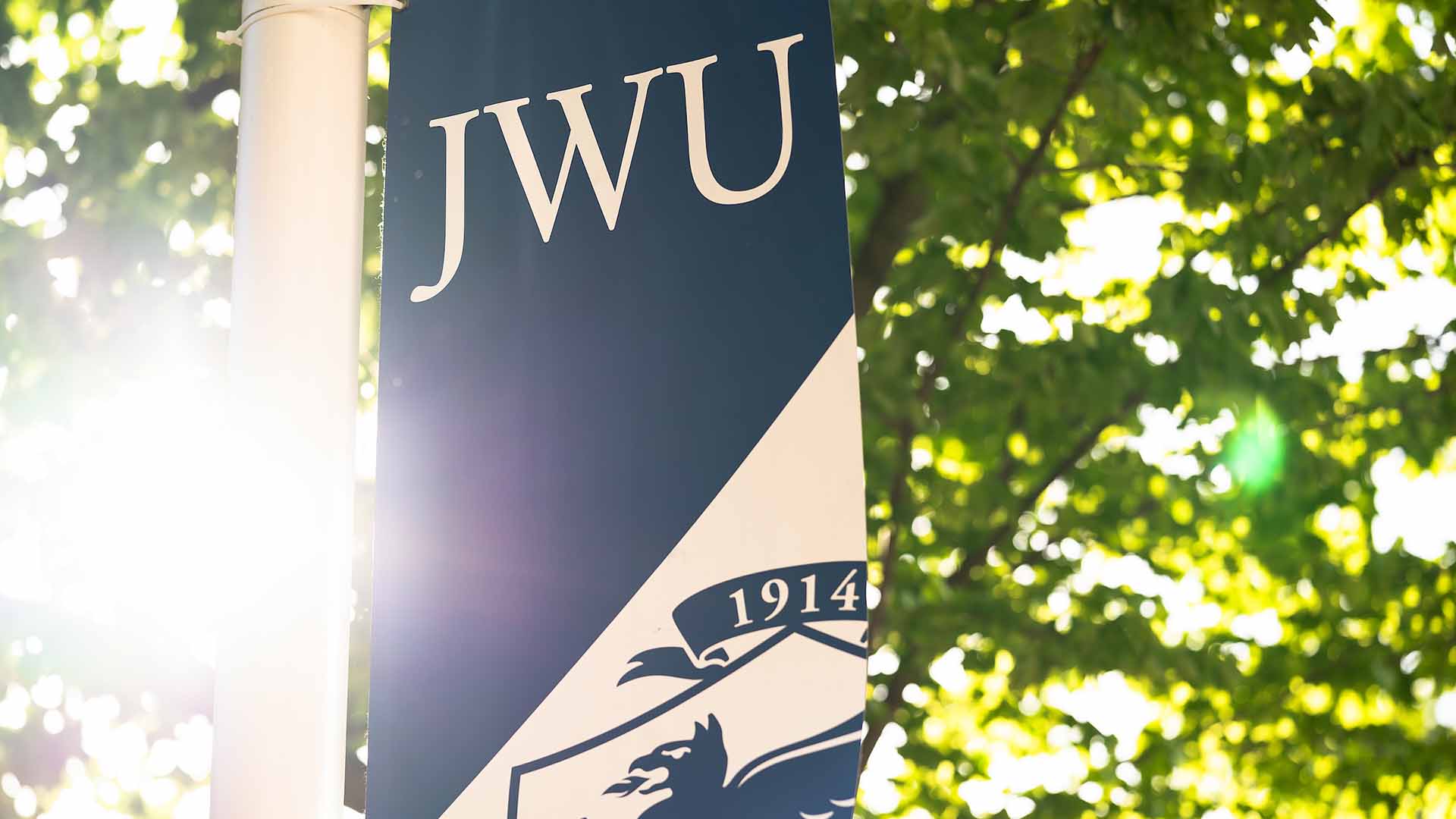 White and navy JWU banner on flagpole.