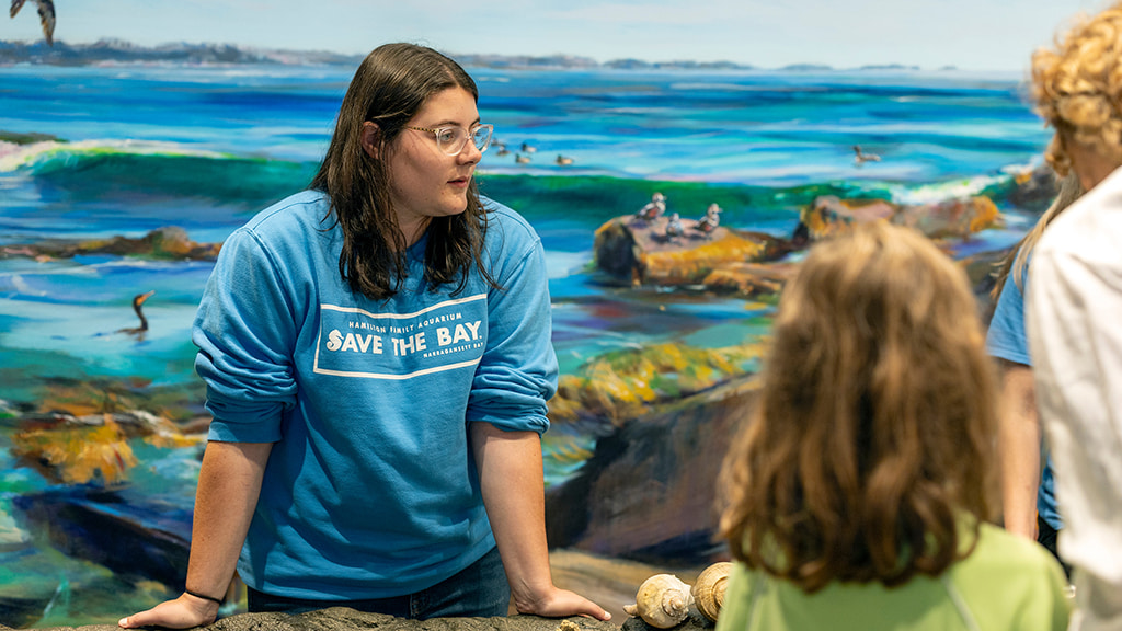 Hailey Sangillo '27 talks to a group of aquarium visitors