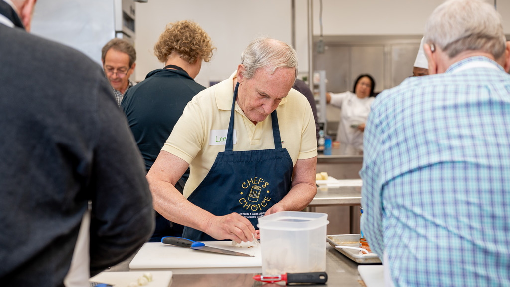 action shot of a man in an apron preparing food