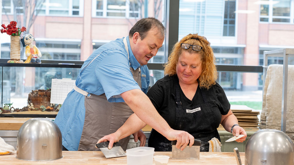 action photo of a man and a woman taking a cooking class