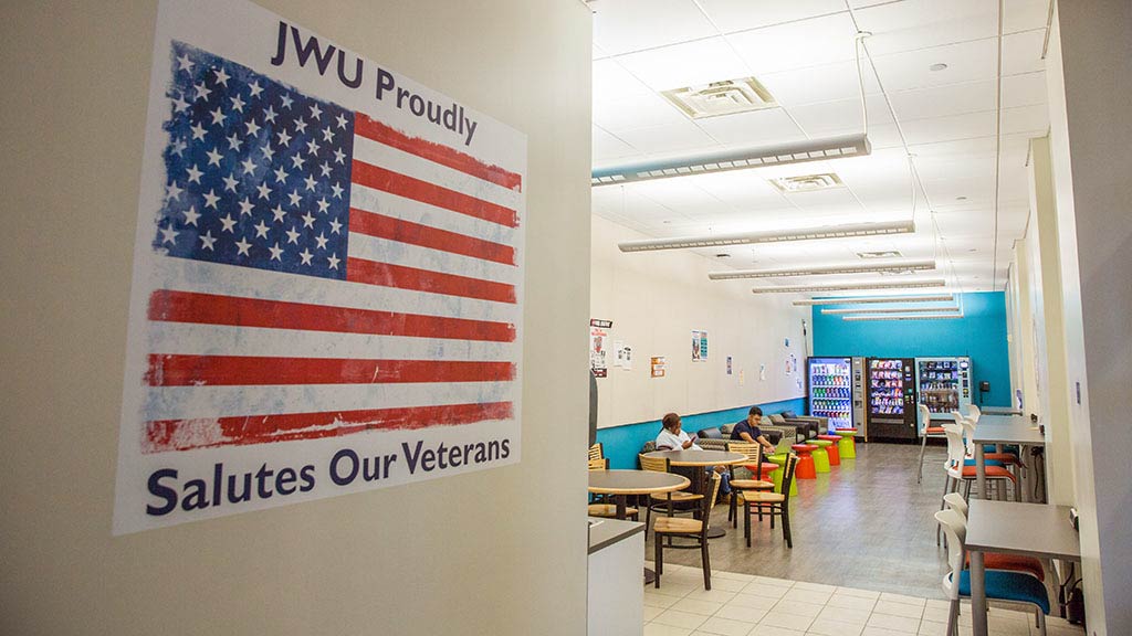 Poster reading, JWU Proudly Salutes Our Veterans, on wall