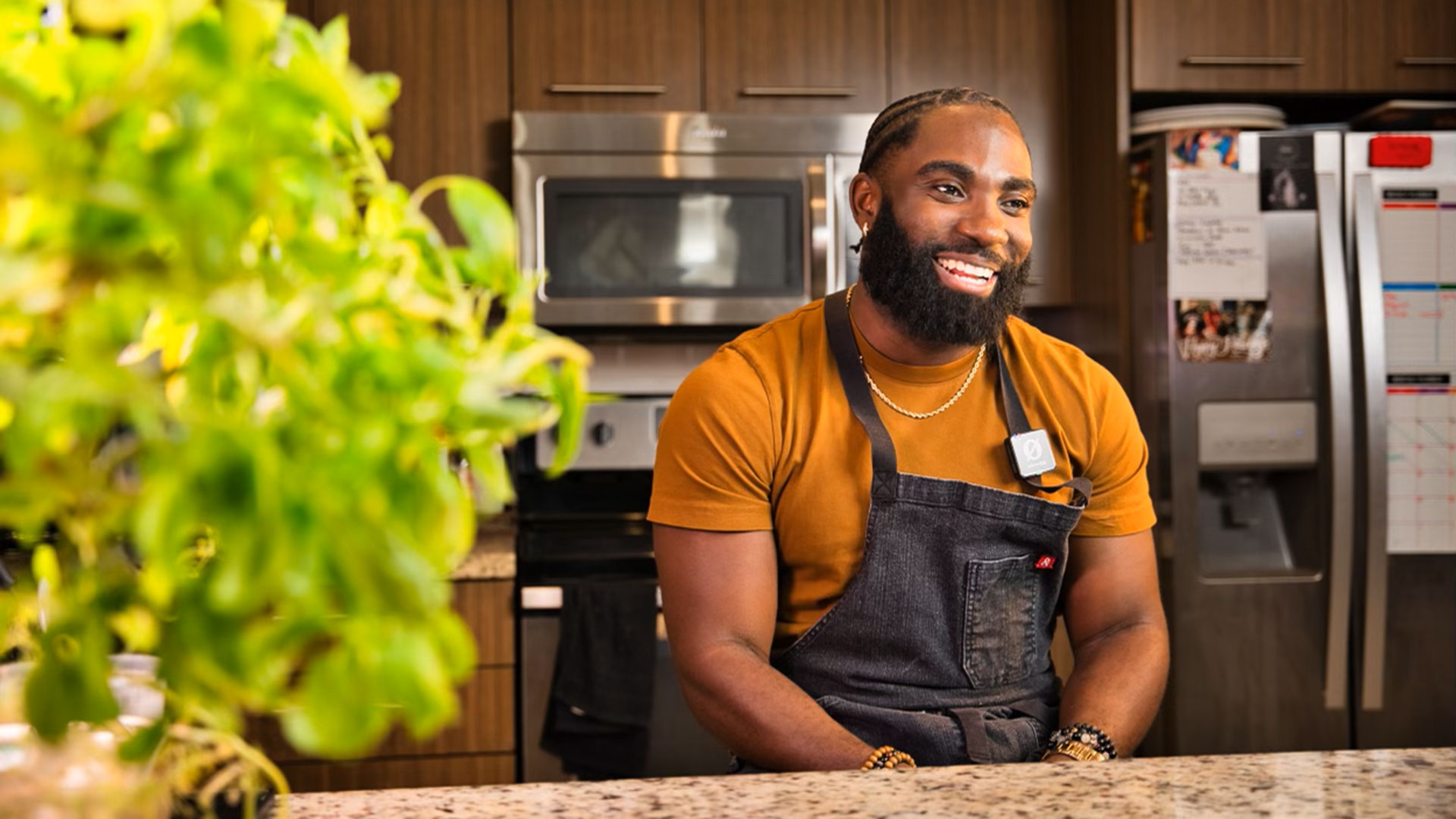 "Chef Nol" Foretia '16 sits smiling at a kitchen countertop