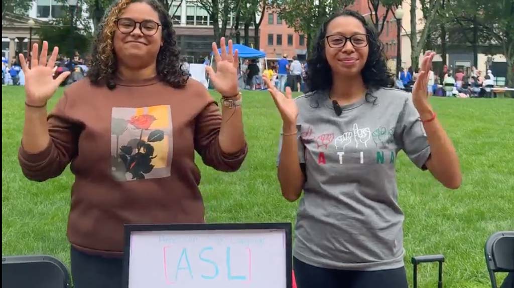 Two students smiling at the American Sign Language table at the Involvement Fest